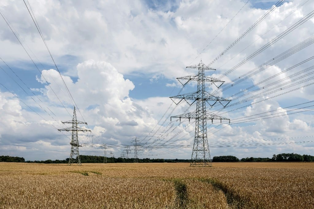 Hoogspanningsmasten in een graanveld: elektriciteitsnet op agrarische grond